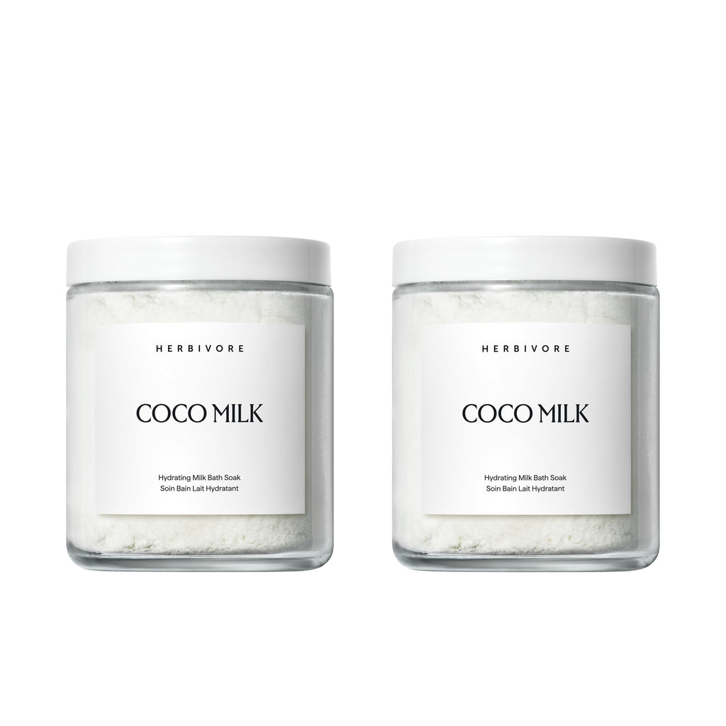 Herbivore Coconut Milk Bath Soak in a jar, featuring a creamy, textured bath product with coconut flakes and a relaxing spa setting.