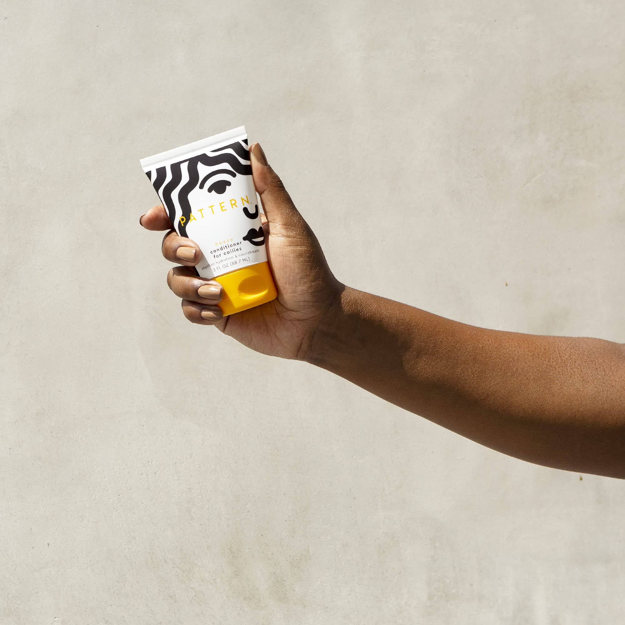 Pattern Beauty Heavy Conditioner for curly hair, rich hydration formula in a large jar with textured label and pump dispenser.