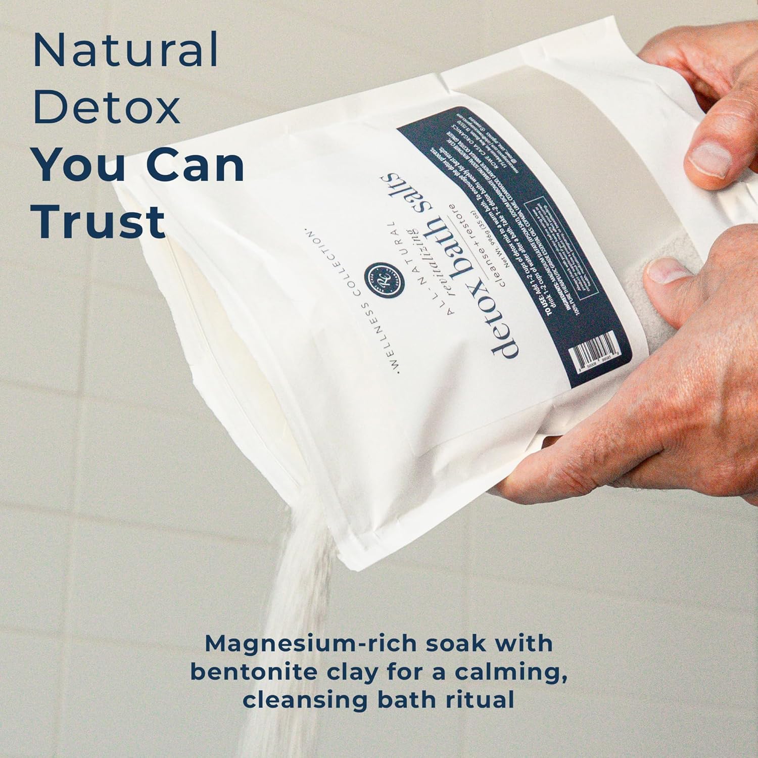 Rowe Casa Organics detox bath salts with magnesium and bentonite clay, shown in a clear glass jar with a scoop on a wooden surface.